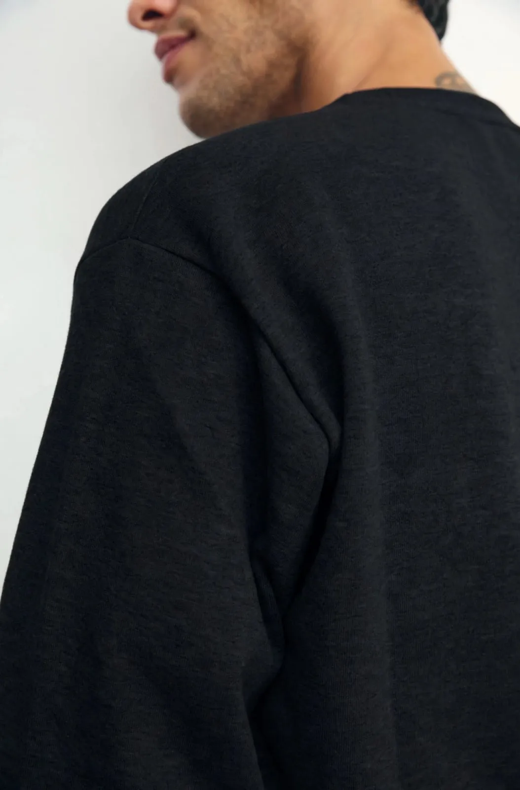Buzo de frisa cuello redondo negro, detalle de la tela